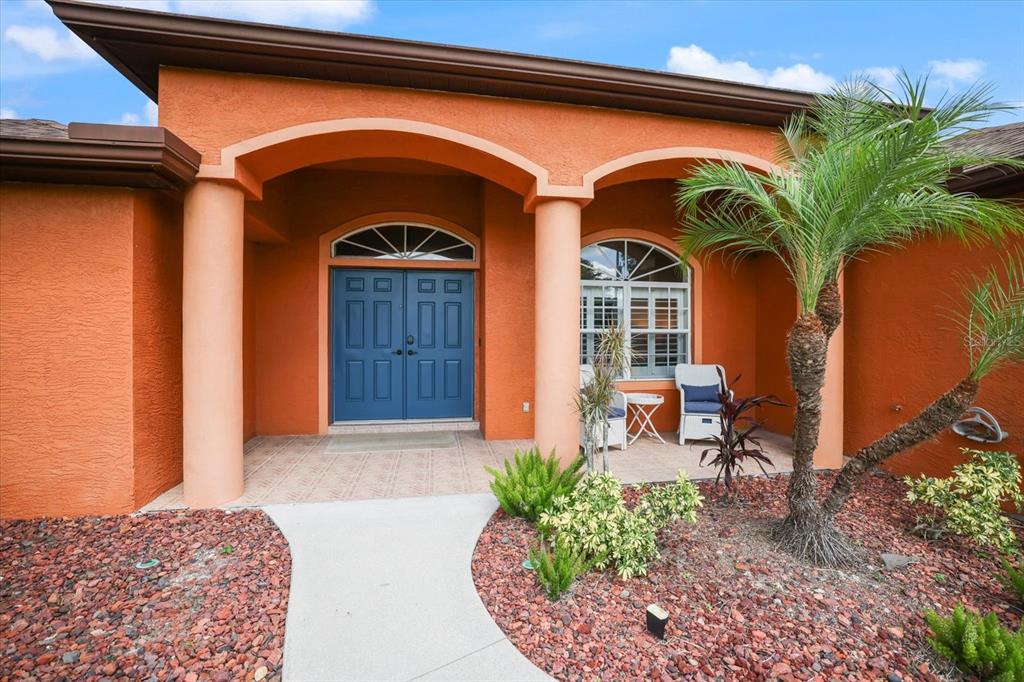 The exterior of a house features an orange stucco facade, a covered entryway, and columns — 20 CORY STREET, PORT CHARLOTTE, FL