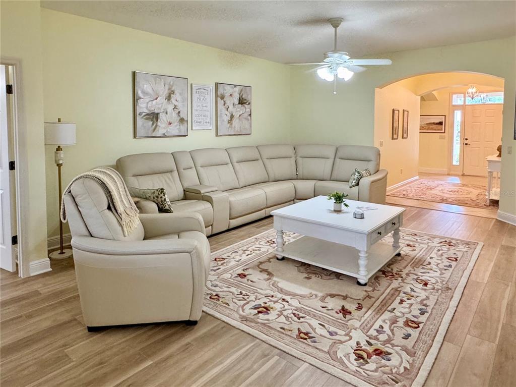 A living room features a beige sectional sofa, a white coffee table, and light wood flooring — 646 MURPHYS ESTATE DRIVE, THE VILLAGES, FL