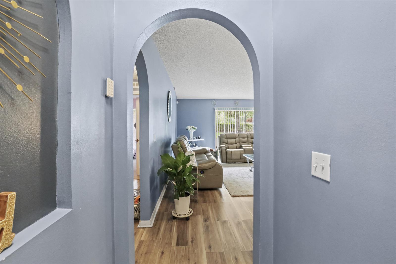 An arched doorway leads from a hallway into a living room with light-colored flooring — 2631 12th Square SW, Vero Beach FL 32968, VERO BEACH, FL