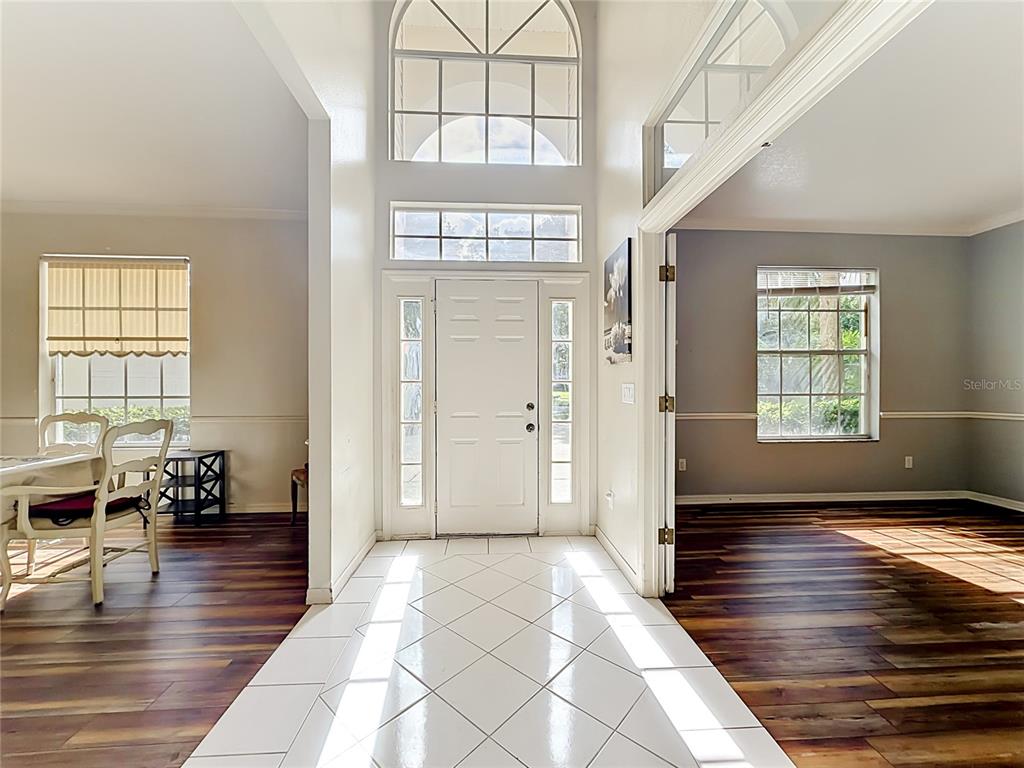 A tiled entryway leads to a front door with a tall arched window above — 1838 SENECA BLVD, WINTER SPRINGS, FL