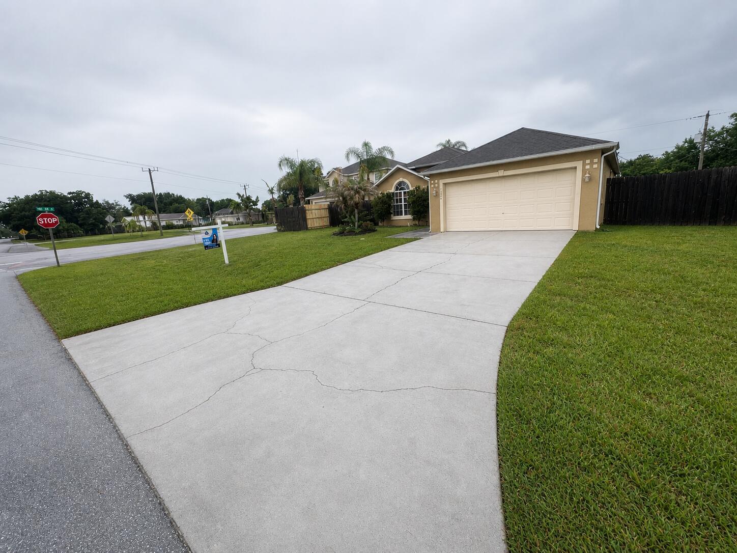 A single-story house with a beige exterior, a two-car garage, and a cracked concrete driveway — 3426 NW 38th Avenue # 3426, Okeechobee FL 34972, OKEECHOBEE, FL