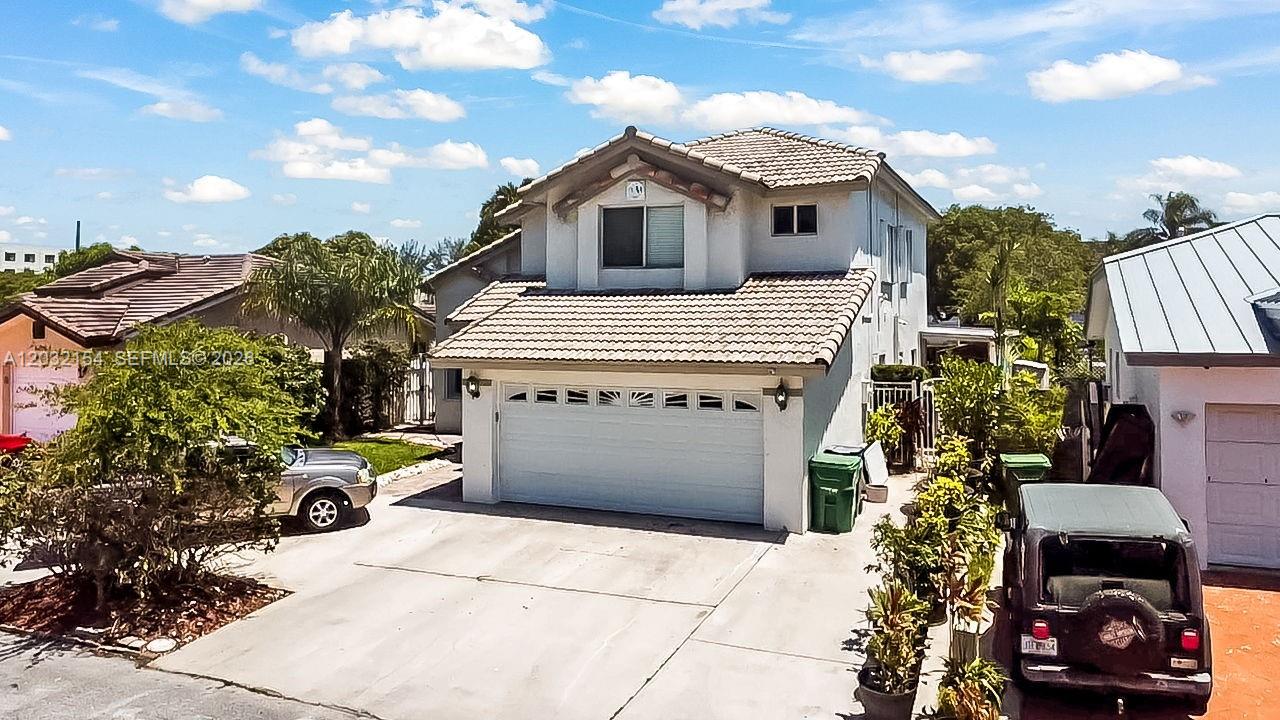 An exterior view of a two-story suburban house with a two-car garage and driveway — 8532 SW 211th Ter, Cutler Bay FL 33189, CUTLER BAY, FL