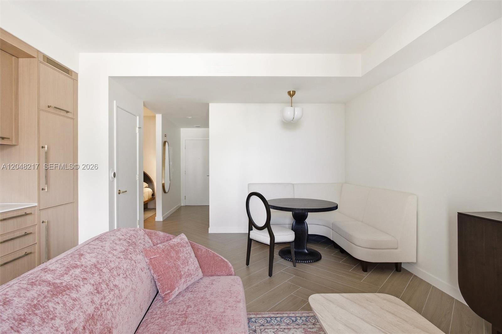 A living and dining area features a pink sofa, a round table, and a banquette — 2700 NW 2nd Ave # 432, Miami FL 33127, MIAMI, FL