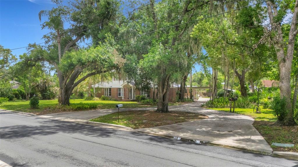 A two-story brick and siding house sits behind a circular driveway and large oak trees — 820 S OAK AVENUE, BARTOW, FL