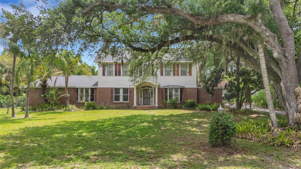 A two-story brick and siding house features a large front lawn and mature oak trees — 820 S OAK AVENUE, BARTOW, FL