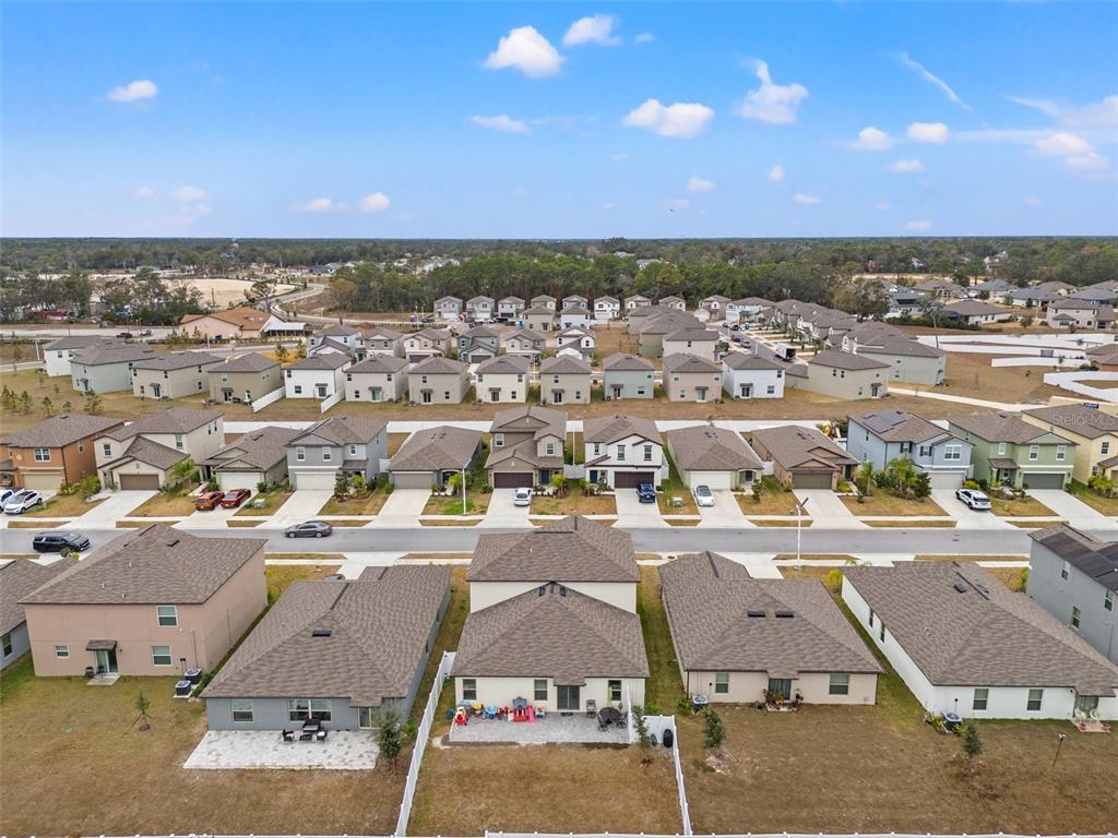 An aerial view shows a suburban neighborhood with rows of single-family homes and backyards — 194 ARGYLL DRIVE, SPRING HILL, FL