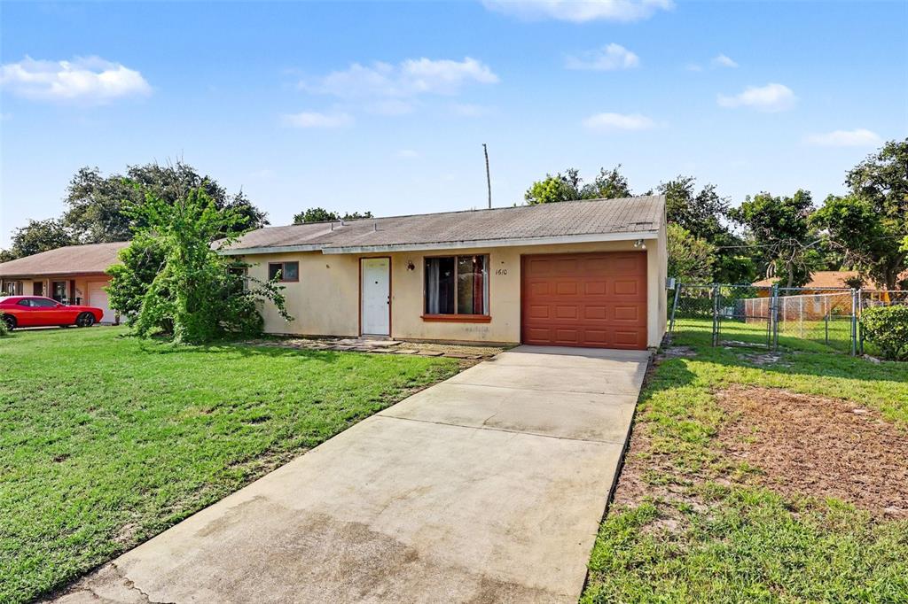 A single-story house with a concrete driveway, a brown garage door, and a grassy yard — 1610 OMEGA STREET NE, PALM BAY, FL
