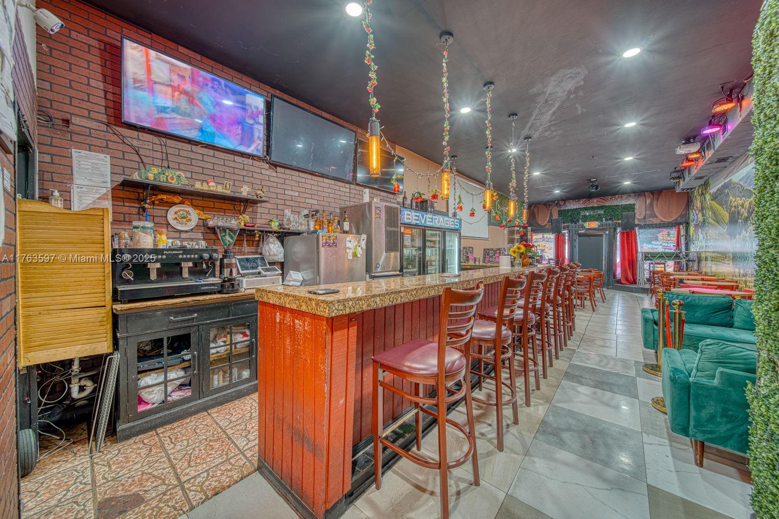 A bar interior features a brick wall, granite-topped counter, bar stools, and tiled flooring — HIGHLY PROFITABLE Restaurant-Bar For Sale on 8th St, Miami FL 33144, MIAMI, FL