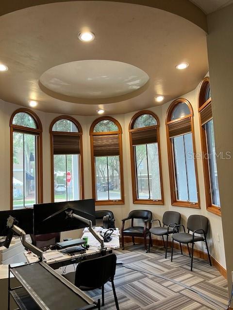 A curved office space features multiple tall windows, recessed lighting, and a desk with equipment — 4965 SW 91ST TERRACE UNIT A, GAINESVILLE, FL