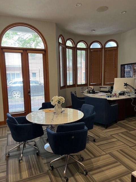 A home office features a round table, blue chairs, and a desk near arched windows — 4965 SW 91ST TERRACE UNIT A, GAINESVILLE, FL