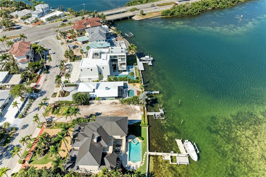 An aerial view shows several waterfront homes with private docks and swimming pools along a bay — 244 N WASHINGTON DRIVE, SARASOTA, FL