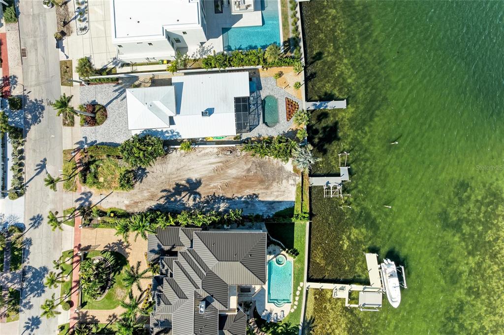 An aerial view shows three waterfront properties, including a vacant lot between two houses — 244 N WASHINGTON DRIVE, SARASOTA, FL