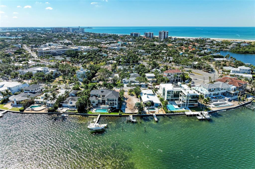 An aerial view shows waterfront luxury homes with private docks and pools along a bay — 244 N WASHINGTON DRIVE, SARASOTA, FL