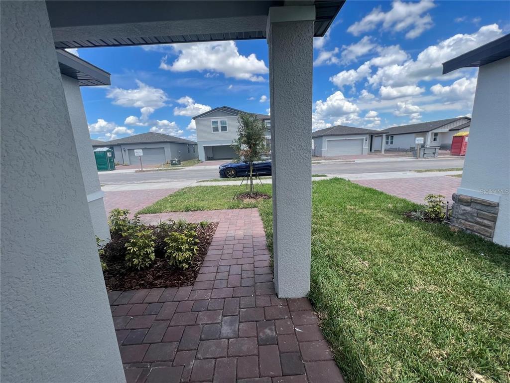 A view from a covered porch looking out toward a street and neighboring houses — 3079 LAUREL OAK LANE, WINTER HAVEN, FL