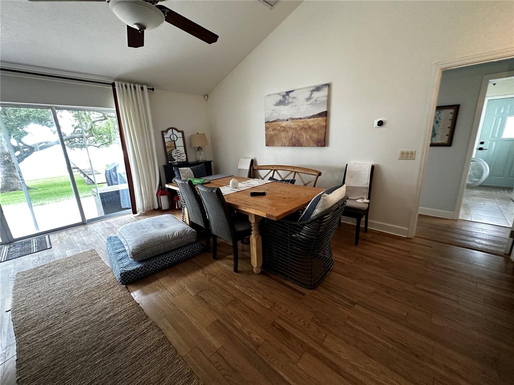 A dining room features a wooden table, mixed seating, and sliding glass doors to a yard — 12595 SE SUNSET HARBOR ROAD, WEIRSDALE, FL