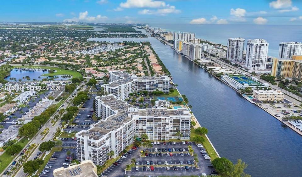 An aerial view shows a large apartment complex situated along a canal near the coast — 800 Parkview Dr # 527, Hallandale Beach FL 33009, HALLANDALE BEACH, FL