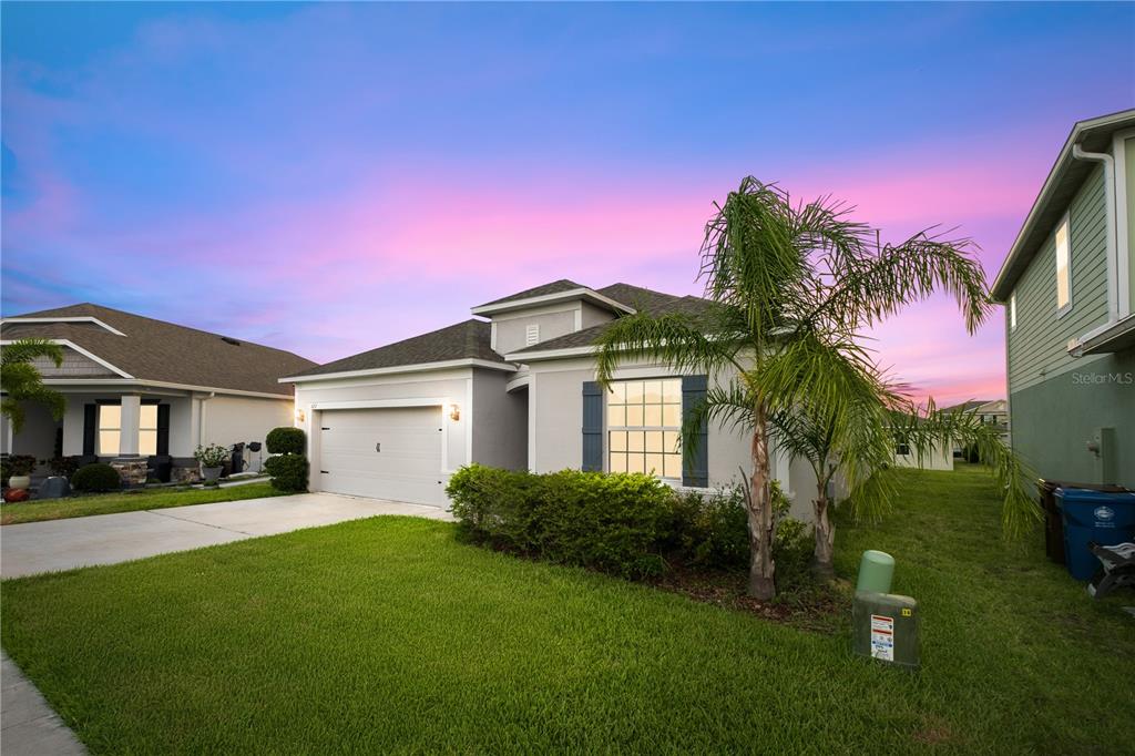 A single-story house with a two-car garage, a palm tree, and a green lawn — 622 TAFT DRIVE, DAVENPORT, FL