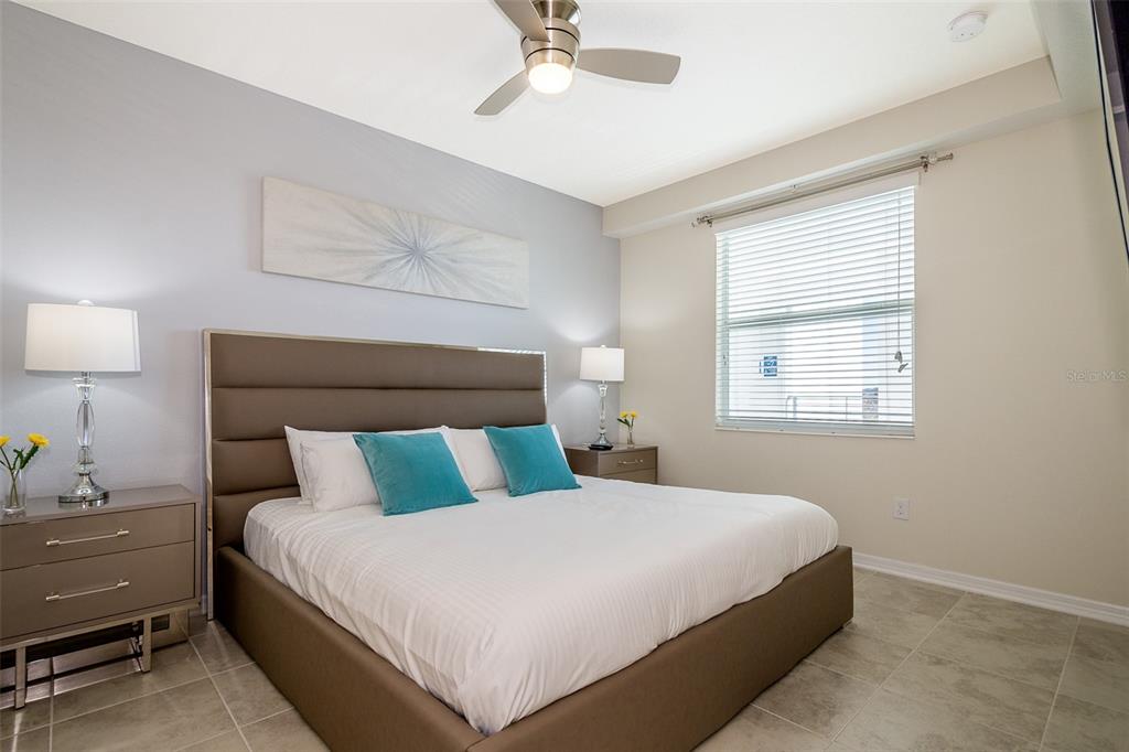 A bedroom features a brown upholstered bed, two nightstands, and a ceiling fan — 4731 CLOCK TOWER DRIVE UNIT 206, KISSIMMEE, FL
