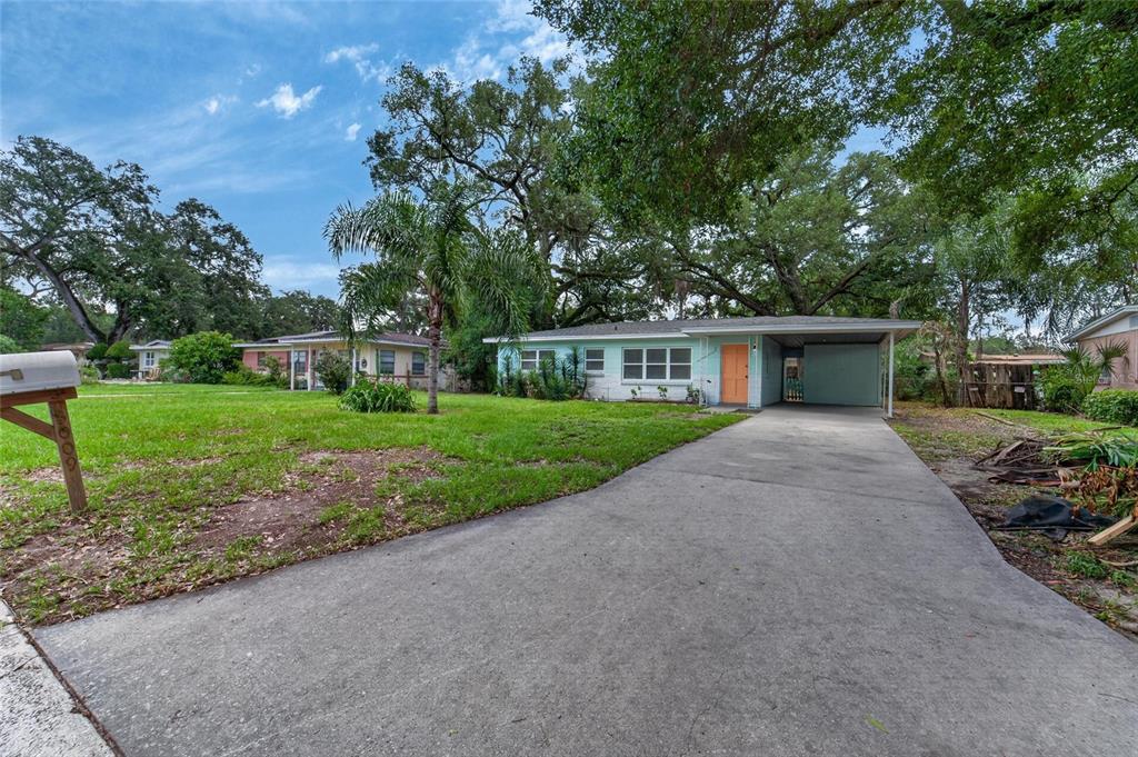 A light blue single-story house with an orange front door and an attached carport — 3009 E FERN STREET, TAMPA, FL