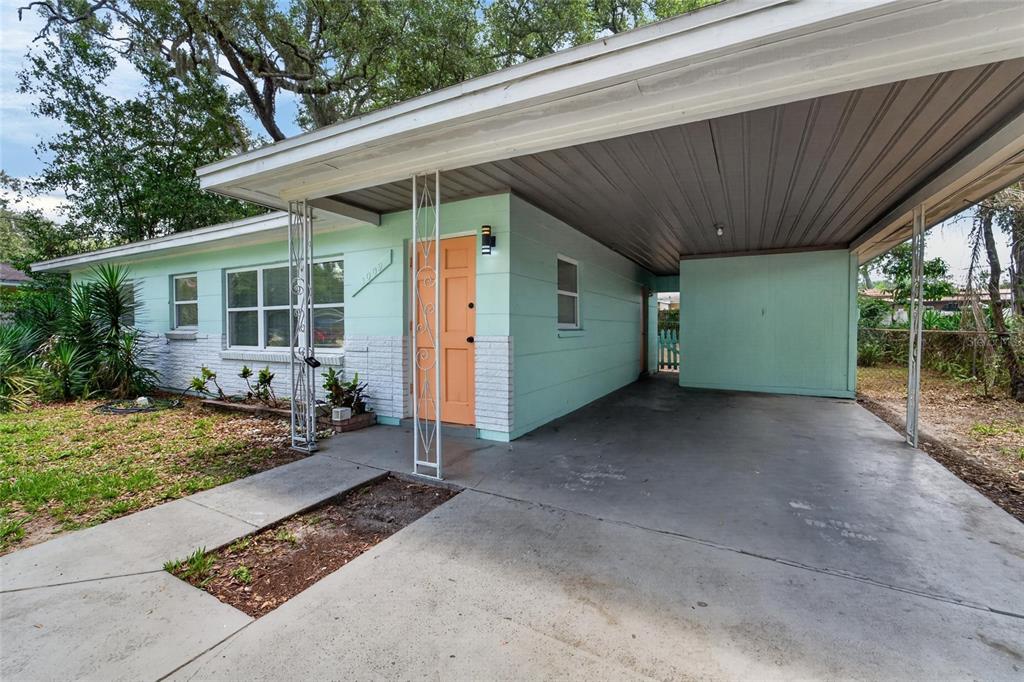 A light green house with a peach front door and a concrete carport — 3009 E FERN STREET, TAMPA, FL