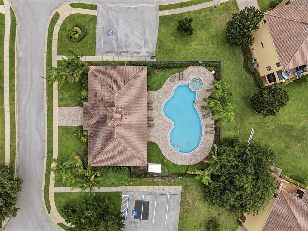 An aerial view shows a community clubhouse with a swimming pool, spa, and parking lots — 1532 CITRINE TRAIL, TARPON SPRINGS, FL