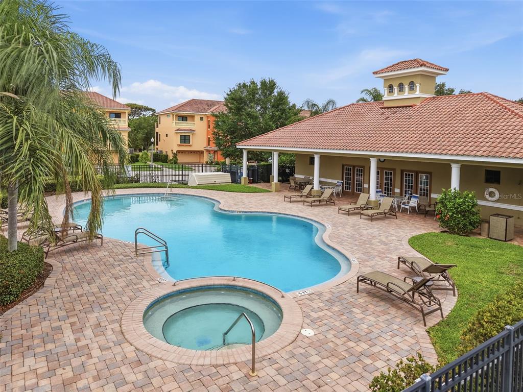 An outdoor swimming pool and hot tub are surrounded by a brick patio and lounge chairs — 1532 CITRINE TRAIL, TARPON SPRINGS, FL