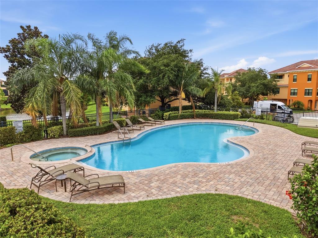 A swimming pool and hot tub are surrounded by a brick paver patio and landscaping — 1532 CITRINE TRAIL, TARPON SPRINGS, FL
