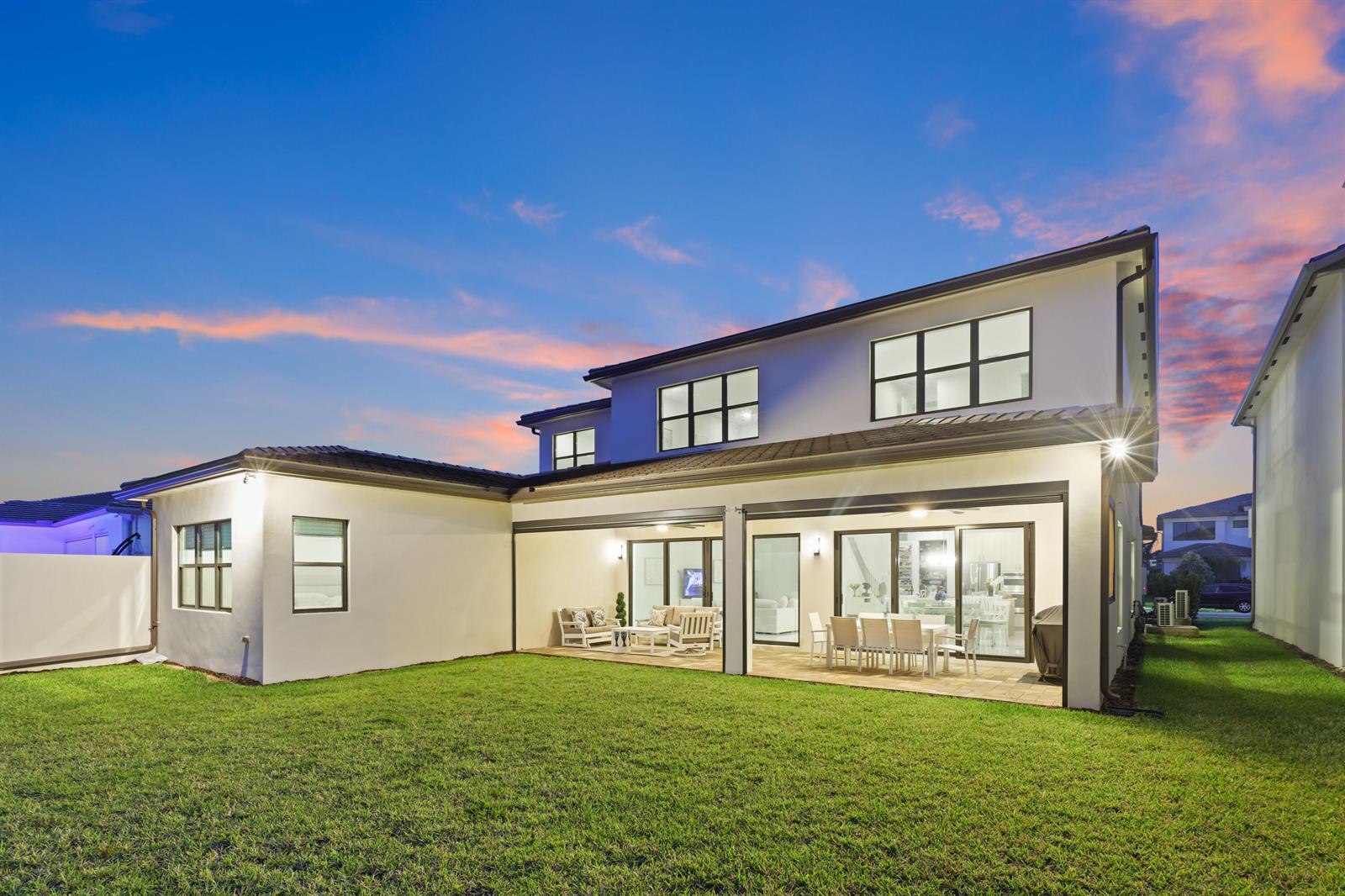 A two-story house with a covered patio, a grassy backyard, and a sunset sky — 20028 Pacific Dunes Drive, Boca Raton FL 33434, BOCA RATON, FL