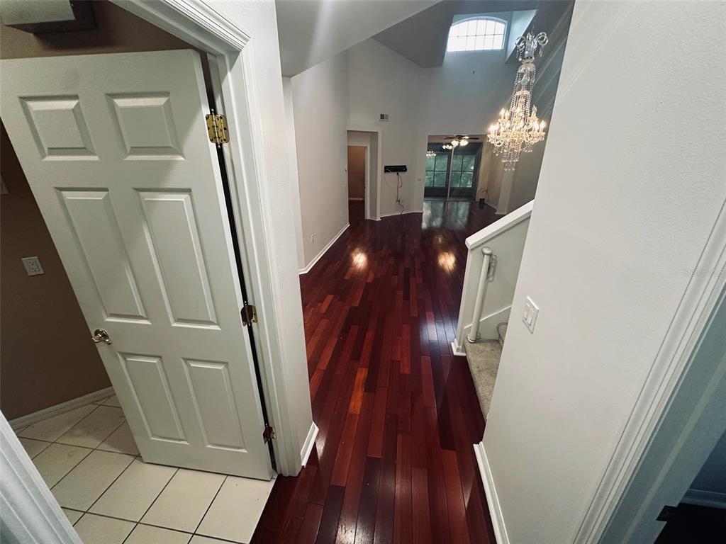 An entryway with hardwood floors leads to a living area featuring a chandelier and skylight — 3125 STONEWATER DRIVE, LAKELAND, FL