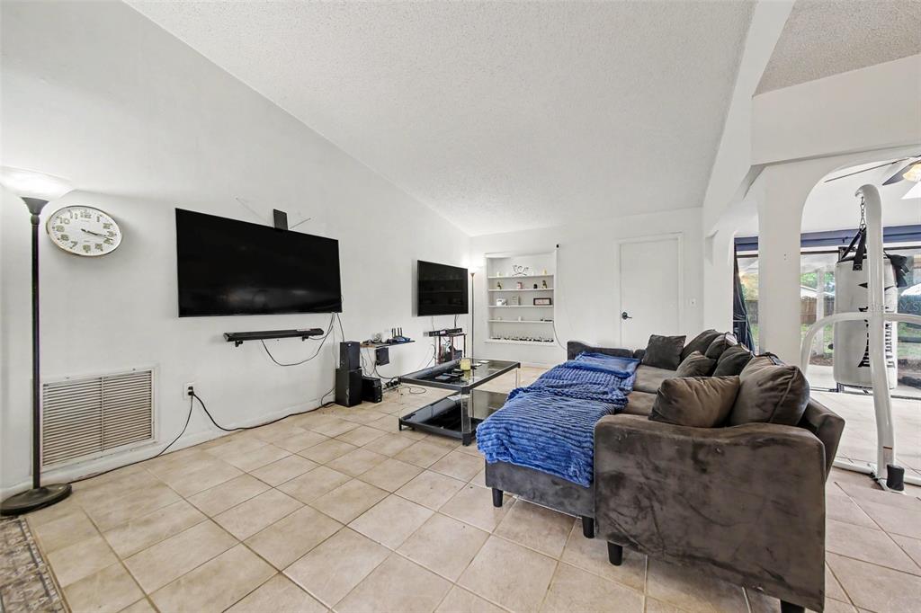 This entryway features a white door, a console table, a bench, and tile flooring — 2008 HOUNDSLAKE DRIVE, WINTER PARK, FL