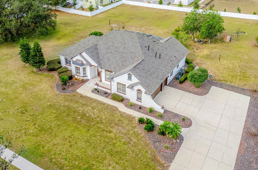 An aerial view shows a single-story house with a shingled roof and a concrete driveway — 5092 NE 81ST BOULEVARD, WILDWOOD, FL