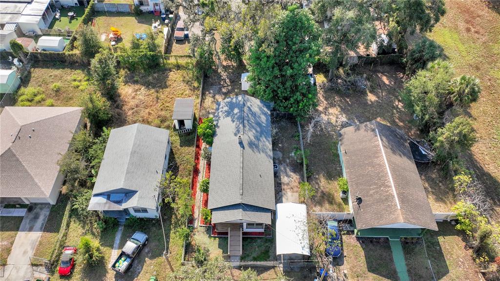 An aerial view shows three houses with driveways, yards, and outbuildings in a residential neighborhood — 3203 E 38TH AVENUE, TAMPA, FL