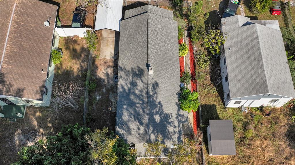 An aerial view shows a rectangular house with a gray roof between two neighboring properties — 3203 E 38TH AVENUE, TAMPA, FL