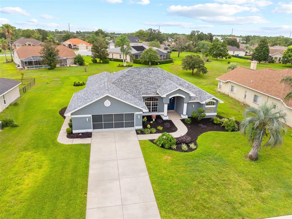 An aerial view shows a gray single-story house with a shingled roof and concrete driveway — 14074 ANDREW SCOTT ROAD, SPRING HILL, FL