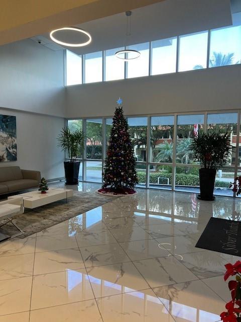 A bright lobby features a Christmas tree, marble floors, and floor-to-ceiling windows — 531 N Ocean Boulevard # 1808, Pompano Beach FL 33062, POMPANO BEACH, FL