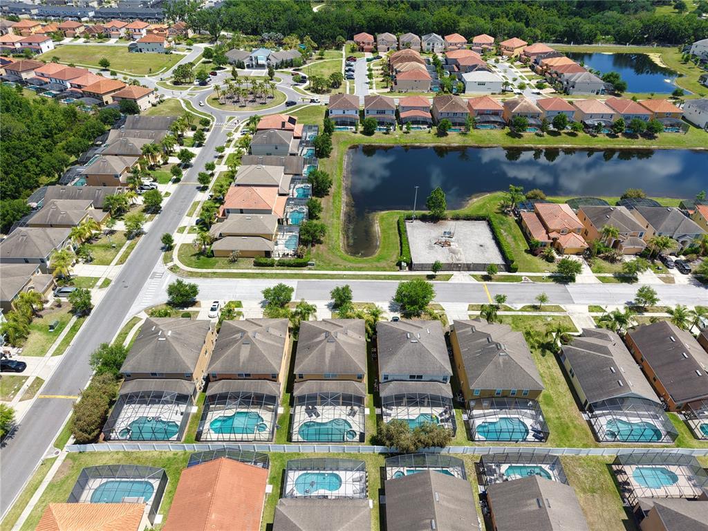 Aerial view of a suburban neighborhood featuring numerous houses with private screened-in swimming pools — 2549 DHARMA CIRCLE, KISSIMMEE, FL