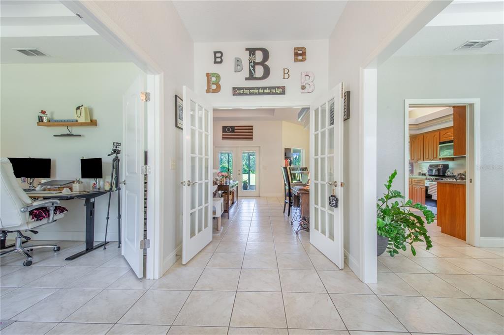 A tiled entryway leads through French doors to a living area with an American flag — 7152 FUSSELL ROAD, POLK CITY, FL