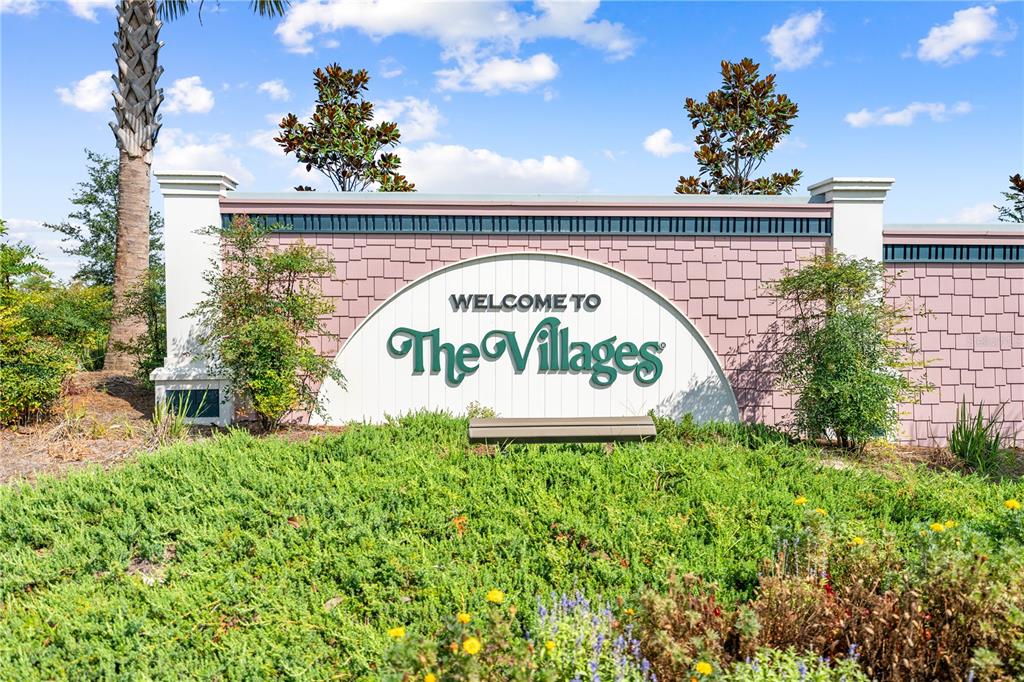 A sign reading Welcome to The Villages stands in front of a landscaped garden — 517 LAMINGTON LANE, THE VILLAGES, FL