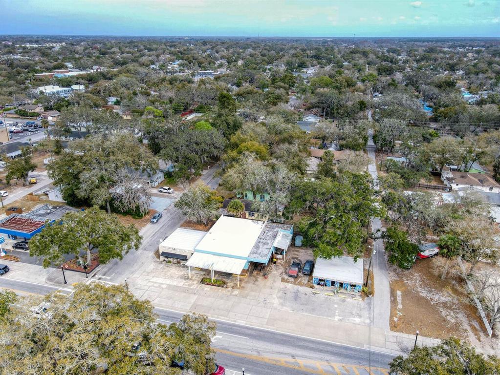 An aerial view shows a commercial building with a parking lot surrounded by trees — 6118 GRAND BOULEVARD, NEW PORT RICHEY, FL