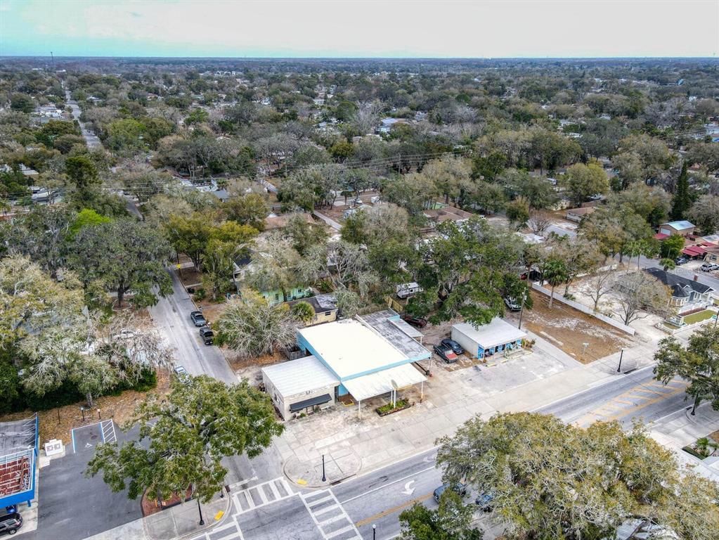 An aerial view shows a commercial building with a flat roof situated near a street — 6118 GRAND BOULEVARD, NEW PORT RICHEY, FL
