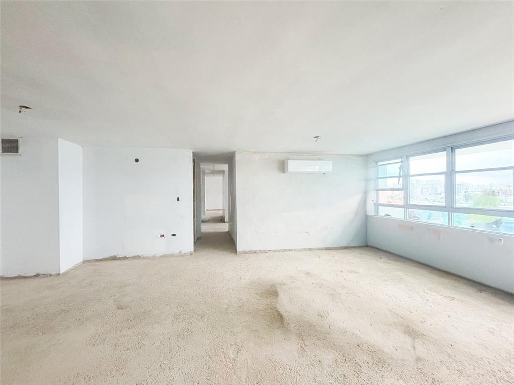 An empty, unfinished room with white walls, a concrete floor, and a large window — 550 AVE FERNANDEZ JUNCOS UNIT 1208, SAN JUAN, PR