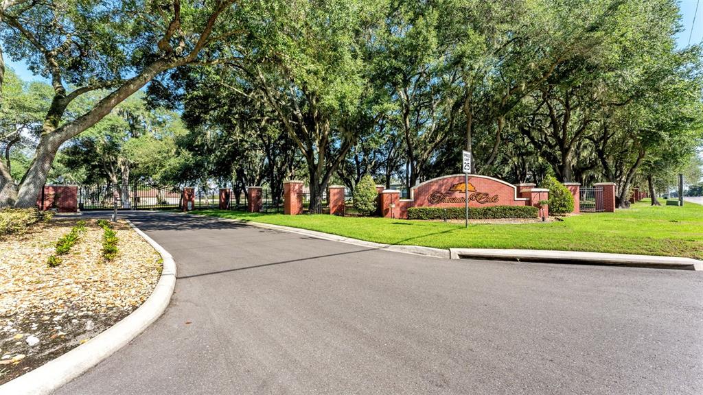 A brick entrance sign for Fountain Oak stands beside a paved road under large trees — 6923 ORIANNA OAKS DRIVE, PLANT CITY, FL
