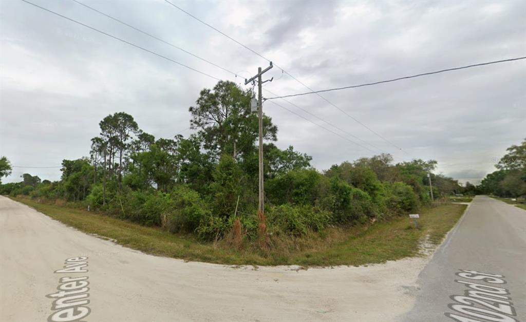 A vacant, wooded corner lot sits at the intersection of two dirt roads — 10234 N CENTER AVENUE, OKEECHOBEE, FL