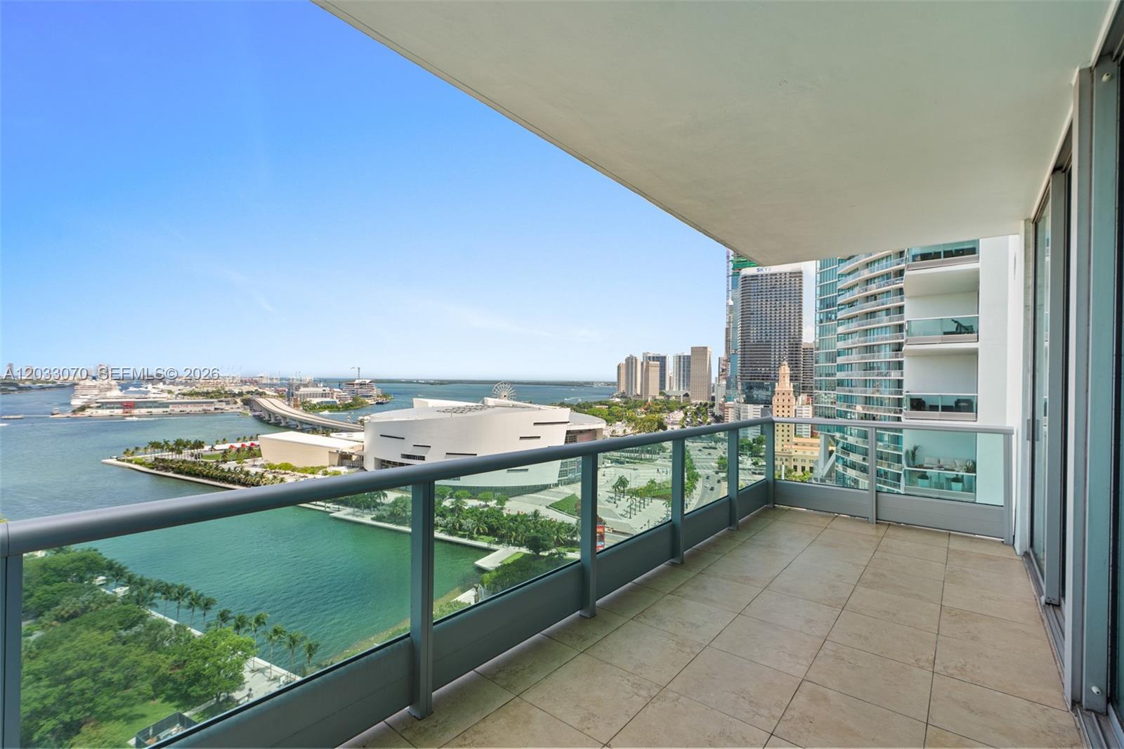 A high-rise balcony with glass railings overlooks the Miami waterfront, cruise port, and city skyline — 900 Biscayne Blvd # 2304, Miami FL 33132, MIAMI, FL