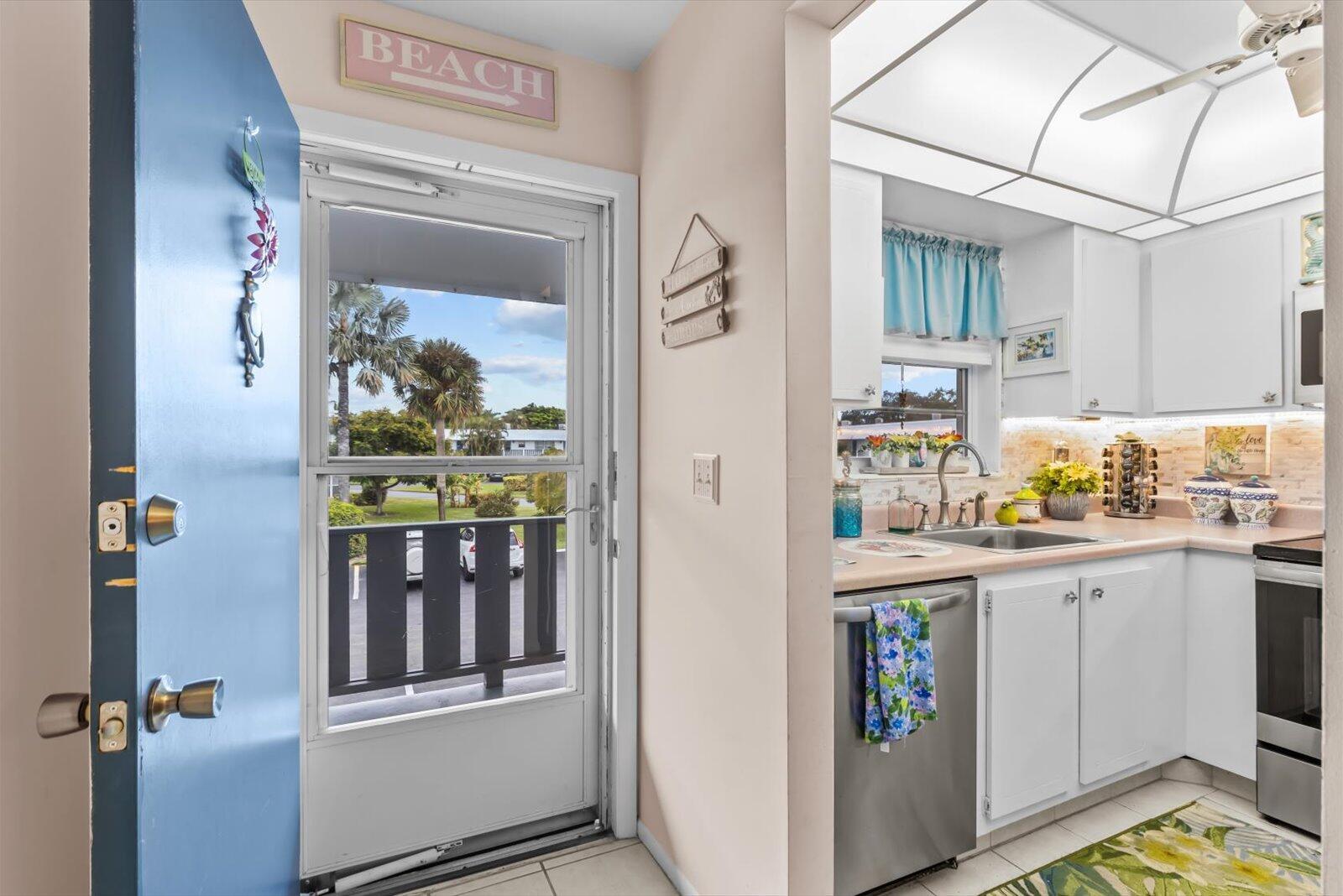 A kitchen with white cabinets and stainless steel appliances is visible next to an entryway — 2929 SE Ocean Boulevard # 9, Stuart FL 34996, STUART, FL