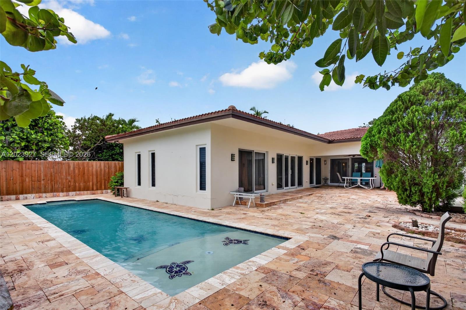 A backyard features a swimming pool with turtle mosaics, a stone patio, and a house — 3408 Dover Rd, Pompano Beach FL 33062, POMPANO BEACH, FL