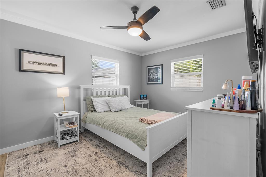 A bedroom features a white bed frame, gray walls, a ceiling fan, and a dresser — 3412 W BAY AVENUE, TAMPA, FL
