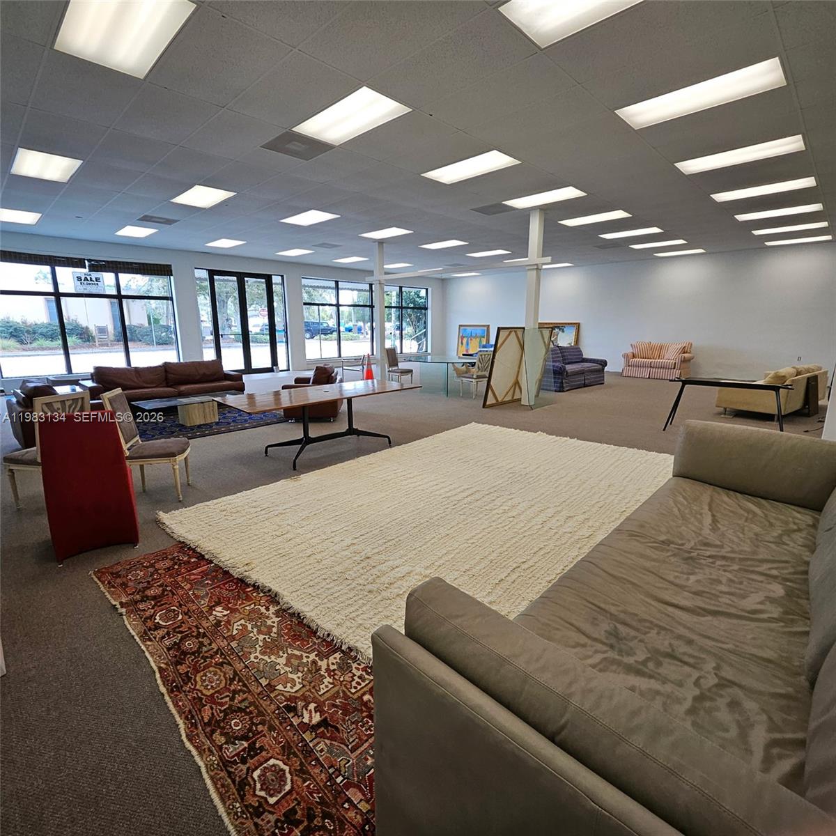 A large, open-plan commercial space features drop ceilings, recessed lighting, and various furniture arrangements — 2025 13th Ave, FL 32960, FL