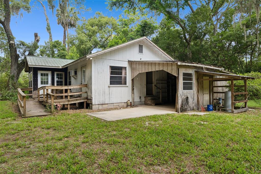 A white, single-story house with a wooden ramp, a carport, and a metal roof — 1555 CHURCH STREET, PIERSON, FL