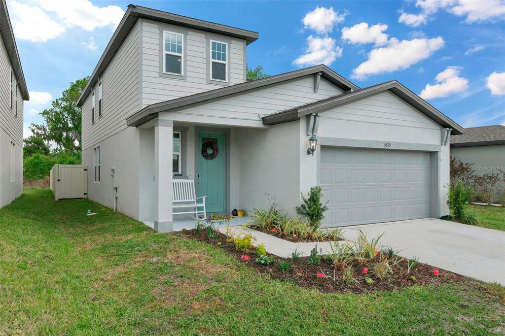 A two-story house with light gray siding, a teal front door, and a two-car garage — 3610 RADIANT MOUNTAIN DRIVE, PLANT CITY, FL